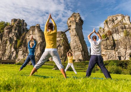 Yoga-Gruppe vor den Externsteinen in Horn-Bad Meinberg im Teutoburger Wald. Foto: Teutoburger Wald Tourismus, Dominik Ketz