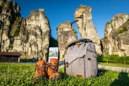 Rucksack und Wanderschuhe vor den Externsteinen