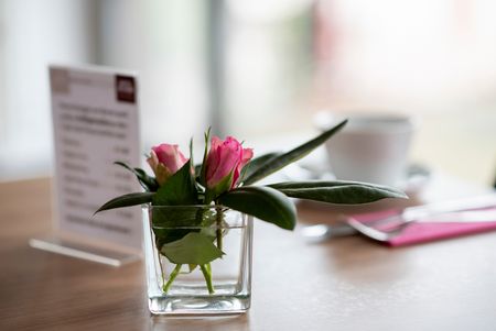 zwei pinke Rosen als Tischdeko im Hotel im Park
