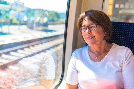 Frau schaut aus dem Zugfenster