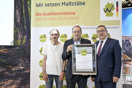 Dr. Axel Lehmann übernimmt auf der Messe Caravan Salon in Düsseldorf 2025 das Zertifikat "Qualitätsweg Wanderbares Deutschland" für das Eggeweg